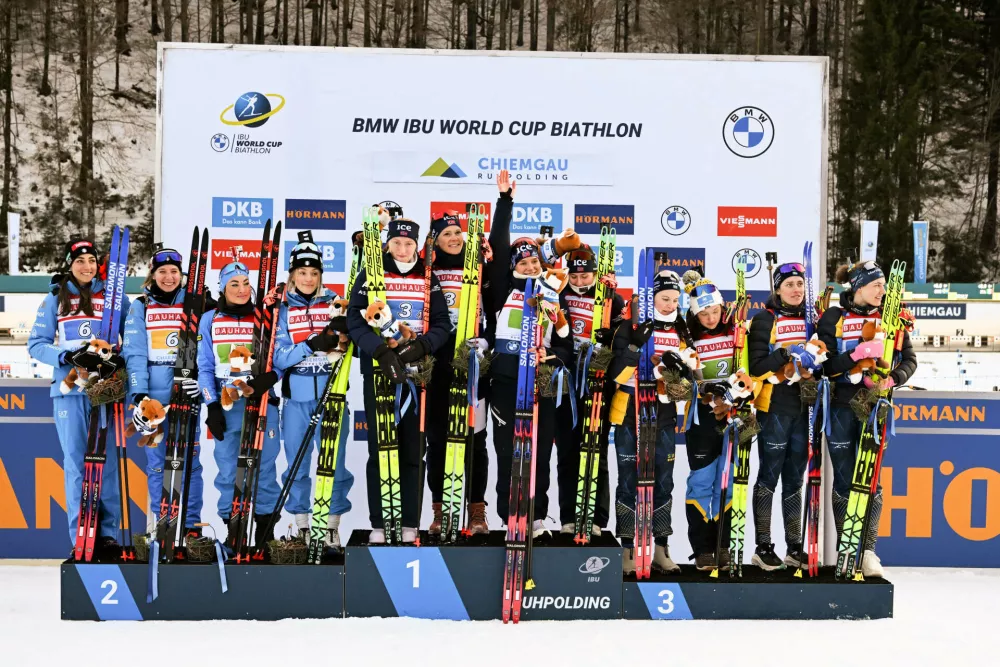 Norway's team, center, winner of the Biathlon women's World Cup, relay 4 x 6 km event, celebrates with second placed Italy, left, and third placed Sweden, in Ruhpolding, Germany, Wednesday, Jan. 14, 2026. (Sven Hoppe/dpa via AP)