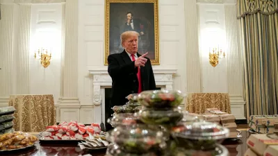 U.S. President Donald Trump speaks in front of fast food provided for the 2018 College Football Playoff National Champion Clemson Tigers due to the partial government shutdown in the State Dining Room of the White House in Washington, U.S., January 14, 2019.   REUTERS/Joshua Roberts   TPX IMAGES OF THE DAY