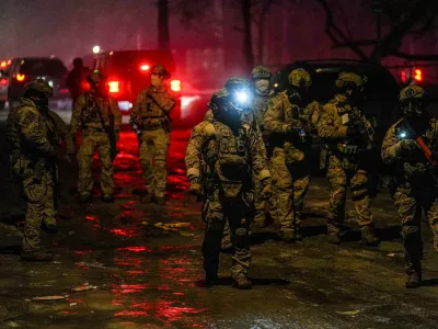 Members of law enforcement gather, as tensions rise after federal law enforcement agents were involved in a shooting incident, a week after a U.S. Immigration and Customs Enforcement (ICE) agent fatally shot Renee Nicole Good, in north Minneapolis, Minnesota, U.S., January 14, 2026. REUTERS/Ryan Murphy