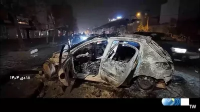 A burnt car lies on the road following unrest sparked by dire economic conditions, in a place given as Tehran, Iran, January 10, 2026, in this screengrab from Iran's state media broadcast footage. IRIB via WANA(West Asia News Agency) via REUTERS ATTENTION EDITORS - THIS PICTURE WAS PROVIDED BY A THIRD PARTY. IRAN OUT. NO COMMERCIAL OR EDITORIAL SALES IN IRAN NO USE BBC PERSIAN. NO USE VOA PERSIAN. NO USE MANOTO. NO USE IRAN INTERNATIONAL. NO USE RADIO FARDA. FOR REUTERS CUSTOMERS ONLY. TEXT OVERLAY FROM SOURCE.