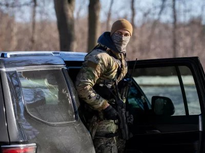 A U.S. Border Patrol officer steps out of his vehicle after blocking a street in Minneapolis, Wednesday, Jan. 14, 2026. (AP Photo/Adam Gray)