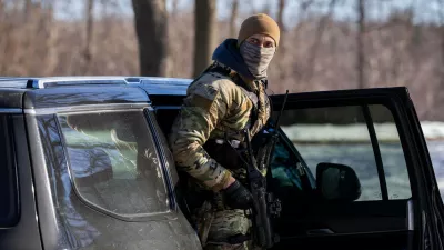 A U.S. Border Patrol officer steps out of his vehicle after blocking a street in Minneapolis, Wednesday, Jan. 14, 2026. (AP Photo/Adam Gray)