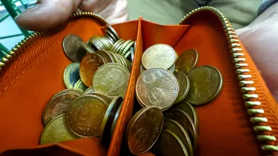 Close-up view of an unzipped orange wallet brimming with assorted euro cent coins, symbolizing budgeting, savings, and small change handling. / Foto: Pavel Samsonov, Getty Images