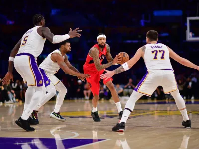 Jan 18, 2026; Los Angeles, California, USA; Toronto Raptors forward Brandon Ingram (3) moves the ball against Los Angeles Lakers center Deandre Ayton (5) guard Marcus Smart (36) and guard Luka Doncic (77) during the second half at Crypto.com Arena. Mandatory Credit: Gary A. Vasquez-Imagn Images