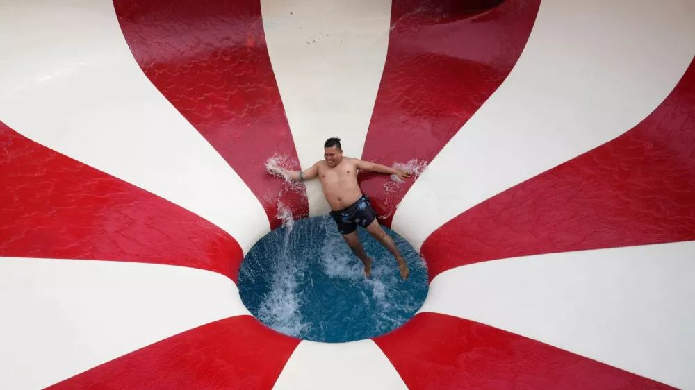 A man tumbles down a water slide in a public pool in the Puente Piedra district outside of Lima, Peru, Sunday, Jan. 18, 2026. (AP Photo/Martin Mejia) / Foto: Martin Mejia