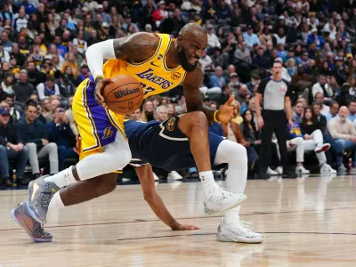 Los Angeles Lakers forward LeBron James (23) fouls Denver Nuggets guard Jamal Murray (27) during the first half of an NBA basketball game Tuesday, Jan. 20, 2026, in Denver. (AP Photo/Jack Dempsey)