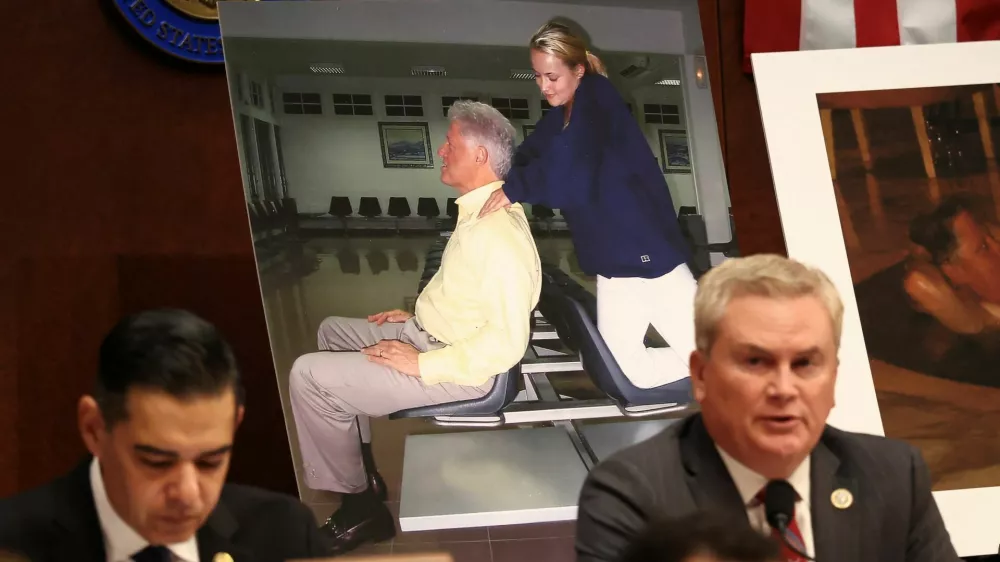 Images of former U.S. President Bill Clinton are on display as Chairman of the House Oversight Committee James Comer (R-KY) speaks during a meeting to vote on whether to hold Clinton and former Secretary of State Hillary Clinton in contempt of Congress for defying subpoenas to testify in the panel's investigation of the late convicted sex offender Jeffrey Epstein, on Capitol Hill in Washington, D.C., U.S., January 21, 2026. REUTERS/Kevin Lamarque