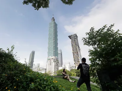 FILE - People take photos with the iconic Taipei 101 skyscraper in the background in Taipei, Taiwan, April 27, 2025. (AP Photo/Chiang Ying-ying, File)