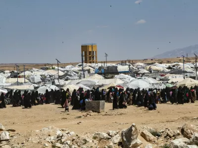 People walk at the Kurdish-run al-Hol camp, which holds relatives of suspected Islamic State (IS) group fighters in the northeastern Hasakeh governorate, on April 18, 2025, as the Syrian Democratic Forces mount a security campaign against IS "sleeper cells" in the camp. Kurdish-run camps and prisons in northeastern Syria still hold about 56,000 people from dozens of countries, many of them the family members of Islamic State group (IS) suspects, more than five years after the jihadists' territorial defeat in Syria.,Image: 989615053, License: Rights-managed, Restrictions:, Model Release: no