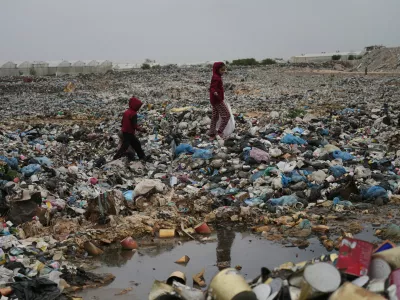 Palestinian girls Jana Al-Basouni and Lina Hamdin collect plastic and paper to burn for cooking and warmth, at a landfill in Khan Younis, Gaza, Thursday, Jan. 22, 2026. (AP Photo/Jehad Alshrafi)