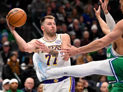 Jan 24, 2026; Dallas, Texas, USA; Los Angeles Lakers guard Luka Doncic (77) looks to pass the ball past Dallas Mavericks forward Dwight Powell (7) during the second half at the American Airlines Center. Mandatory Credit: Jerome Miron-Imagn Images