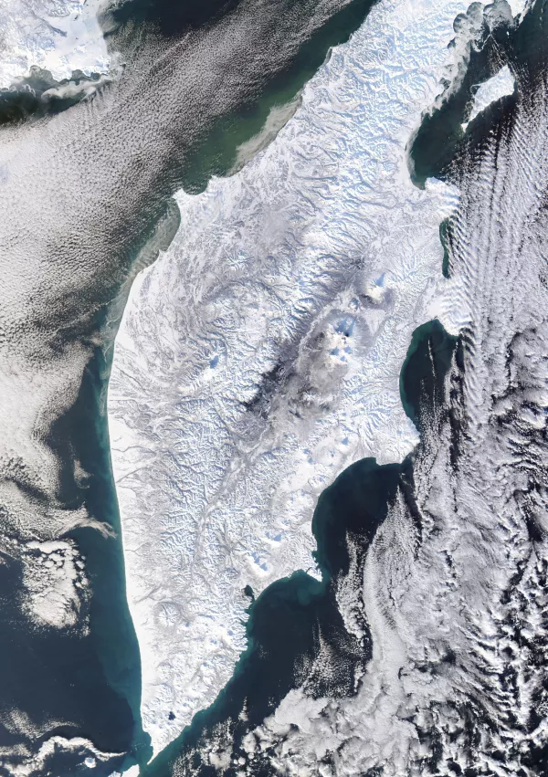 Na polotoku so vidni &scaron;tevilni krožni, s snegom prekriti vulkanski vrhovi, saj je Kamčatka eno najbolj vulkansko aktivnih območij na svetu. / Foto: Nasa