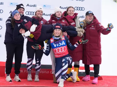 United States' Mikaela Shiffrin, center, foreground, poses with members of the women's US ski team after winning an alpine ski, women's World Cup slalom, in Spindleruv Mlyn, Czech Republic, Sunday, Jan. 25, 2026. (AP Photo/Giovanni Auletta)