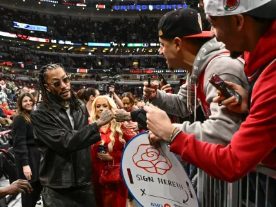 Former Chicago Bulls player Derrick Rose, left, fist bumps fans before an NBA basketball game against the Boston Celtics, Saturday, Jan. 24, 2026, in Chicago. Rose's jersey will be retired after the game today. (AP Photo/Matt Marton)