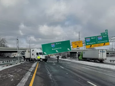 This photo provided by Metropolitan Nashville Police Department shows the wreckage of a tractor trailer under a fallen road sign along an icy highway Monday, Jan. 26, 2026, in Nashville, Tenn. (Metropolitan Nashville Police Department via AP)