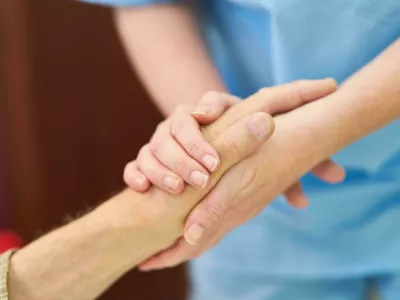 2J8YW10 Nurse with a face mask because of Covid-19 plays dominoes with seniors in the nursing home Foto: Reuters/Alamy