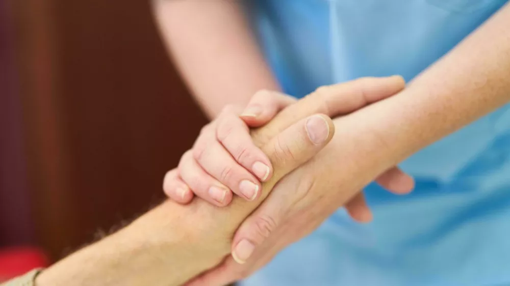 2J8YW10 Nurse with a face mask because of Covid-19 plays dominoes with seniors in the nursing home Foto: Reuters/Alamy