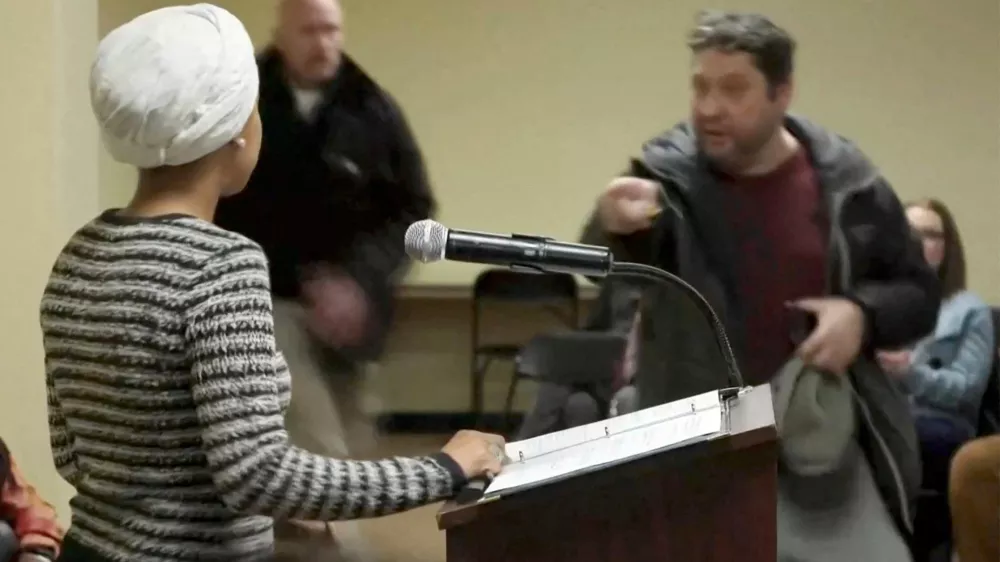 A man shouts at U.S. Representative Ilhan Omar (D-MN) after spraying an unidentified liquid in her direction, during a town hall meeting days after a man identified as Alex Pretti was fatally shot by federal immigration agents trying to detain him, in Minneapolis, Minnesota, U.S., January 27, 2026 in a still image from video. REUTERS/Maria Alejandra Cardona   TPX IMAGES OF THE DAY
