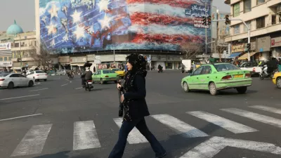 A woman walks past an anti-U.S. billboard in Tehran, Iran, January 26, 2026. Majid Asgaripour/WANA (West Asia News Agency) via REUTERS ATTENTION EDITORS - THIS PICTURE WAS PROVIDED BY A THIRD PARTY