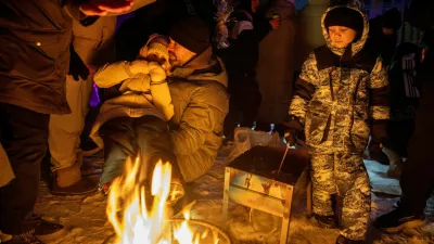 FILE PHOTO: People warm themselves at a bonfire at a party with DJ and food at a sports ground in a neighborhood left without electricity after recent Russian strikes on the capital's civilian infrastructure, amid Russia's attack on Ukraine, during sub-zero temperatures in Kyiv, Ukraine January 24, 2026. REUTERS/Thomas Peter/File Photo