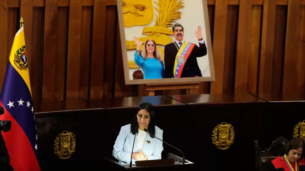 Venezuelan acting President Delcy Rodriguez speaks under a framed image of former President Nicolas Maduro and his wife Cilia Flores, during a ceremony marking the opening of the new judicial year at the Supreme Tribunal of Justice in Caracas, Venezuela, Friday, Jan. 30, 2026. (AP Photo/Ariana Cubillos)