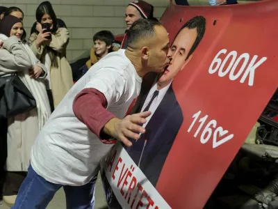 A man kisses a hood of a car with an image of Kosovo's Prime Minister and Levizja Vetevendosje (Movement for Self-Determination) party leader Albin Kurti, as the party leads in early vote results, on the day of a snap parliamentary election, nearly a year after a political deadlock that prevented the formation of a new government, in Pristina, Kosovo, December 28, 2025. REUTERS/Valdrin Xhemaj REFILE - CORRECTING INFORMATION FROM "KISSES A POSTER" TO "KISSES A HOOD OF A CAR".