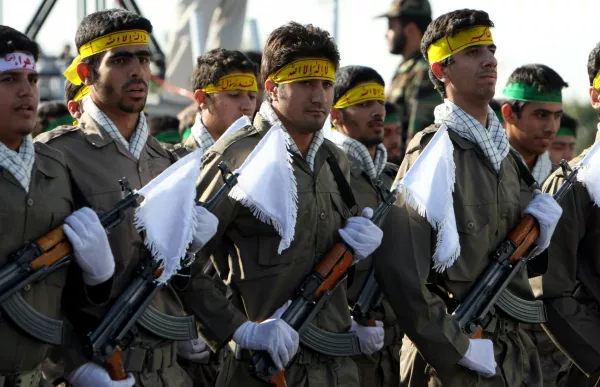 FILE- ADVANCED TO GO WITH STORY SLUG IRAN GUARDS BY SALLY BUZBEE, Militias of Iran's Revolutionary Guards (Basiji) parade as they have headbands sign: Great Allah, There is no god but Allah, Muhammad is his messenger, during large-scale military parades in Tehran to mark the 27th anniversary of the Iraqi invasion of Iran that sparked the bloody 1980-88 war, in Tehran, Iran in this photo taken on Saturday Sep. 22, 2007. They own car factories and construction firms, operate newspaper groups and oil fields and increasingly, serve in parliament or become provincial governors. To supporters, the Revolutionary Guards are the cream of the country's talent. (AP Photo/Hasan Sarbakhshian,file)