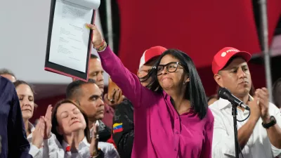 Venezuela's acting President Delcy Rodriguez takes part in a rally holding up a copy of a new law after lawmakers approved legislation opening the nation's oil sector to privatization, at the Miraflores Palace in Caracas, Venezuela, Thursday, Jan. 29, 2026. (AP Photo/Ariana Cubillos)