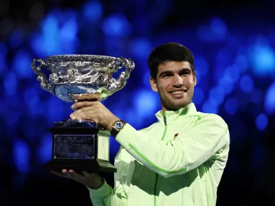 Tennis - Australian Open - Melbourne Park, Melbourne, Australia - February 1, 2026 Spain's Carlos Alcaraz celebrates with the trophy after winning the Australian Open men's singles against Serbia's Novak Djokovic. Alcaraz becomes the youngest man to win all four grand slam titles. REUTERS/Tingshu Wang