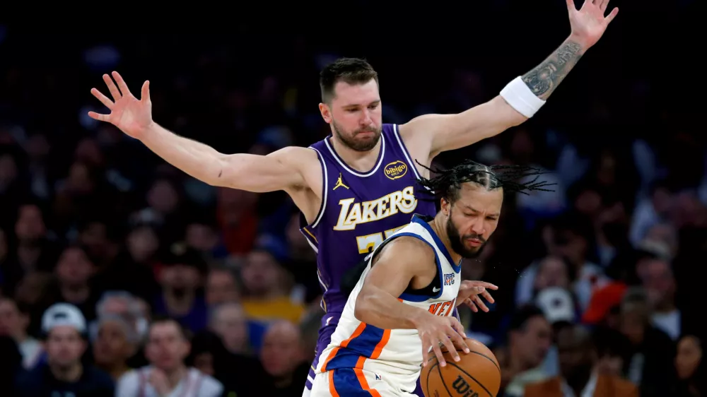 Los Angeles Lakers guard Luka Doncic, top, defends against New York Knicks guard Jalen Brunson, bottom, during the second half of an NBA basketball game, Sunday, Feb. 1, 2026, in New York. (AP Photo/John Munson)
