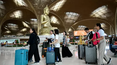 Passengers walk with their luggage past a statue of Buddha on the inauguration day of the newly built Techo International Airport in Kandal province, on the outskirts of Phnom Penh, on September 9, 2025. A new major airport serving the capital Phnom Penh began operations.,Image: 1035477357, License: Rights-managed, Restrictions:, Model Release: no