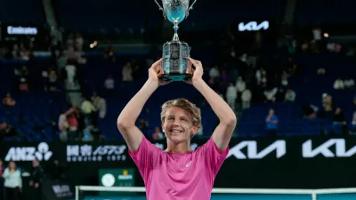 Ziga Sesko of Slovenia holds his trophy aloft after defeating Keaton Hance of the U.S. in the boy's singles final at the Australian Open tennis championship in Melbourne, Australia, Sunday, Feb. 1, 2026. (AP Photo/Dar Yasin)