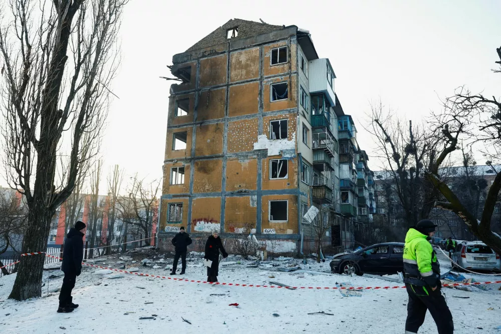 People, including residents and the police, walk near an apartment building hit by a Russian drone strike, amid Russia's attack on Ukraine, in Kyiv, Ukraine February 3, 2026. REUTERS/Valentyn Ogirenko