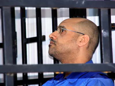 FILE PHOTO: Saif al-Islam Gaddafi, son of late Libyan leader Muammar Gaddafi, attends a hearing behind bars in a courtroom in Zintan May 25, 2014. REUTERS/Stringer/File Photo