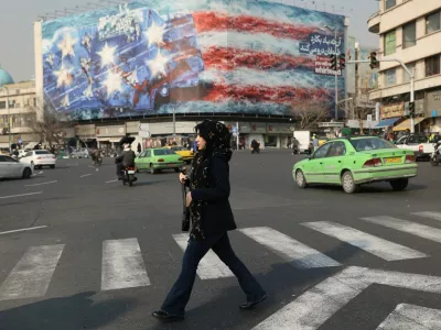 A woman walks past an anti-U.S. billboard in Tehran, Iran, January 26, 2026. Majid Asgaripour/WANA (West Asia News Agency) via REUTERS ATTENTION EDITORS - THIS PICTURE WAS PROVIDED BY A THIRD PARTY