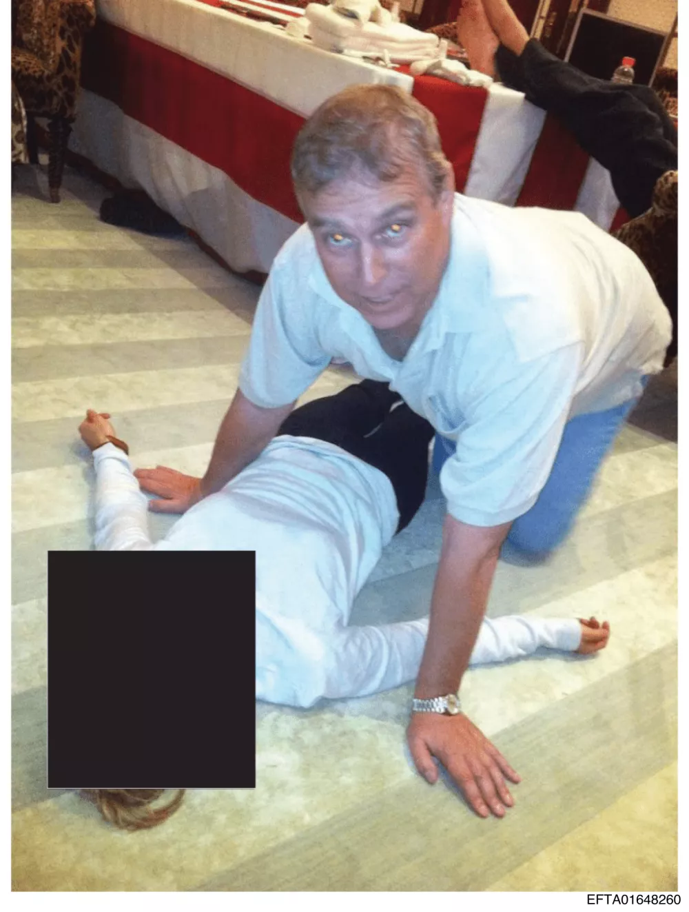 EDS NOTE: GRAPHIC CONTENT - This undated photo, released and redacted by the U.S. Department of Justice as part of the Jeffrey Epstein files, shows Andrew Mountbatten-Windsor, formerly known as Prince Andrew, leaning over an unidentified person. (U.S. Department of Justice via AP)