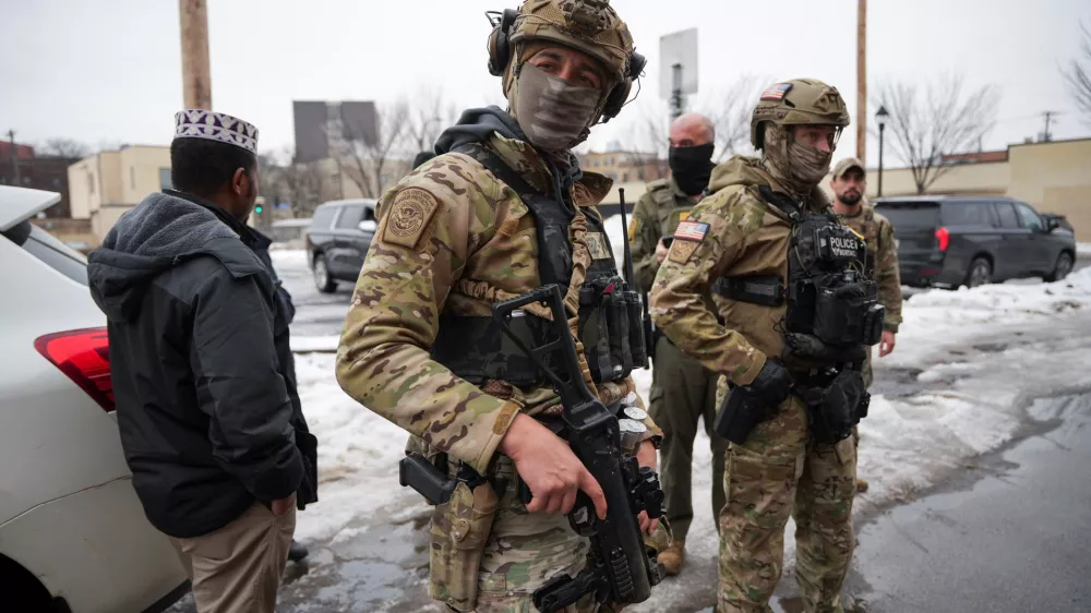 Federal agents stand next to a man they approached during immigration enforcement action the day after the fatal shooting of Renee Nicole Good by a U.S. Immigration and Customs Enforcement (ICE) agent, in Minneapolis, Minnesota, U.S., January 8, 2026. REUTERS/Tim Evans