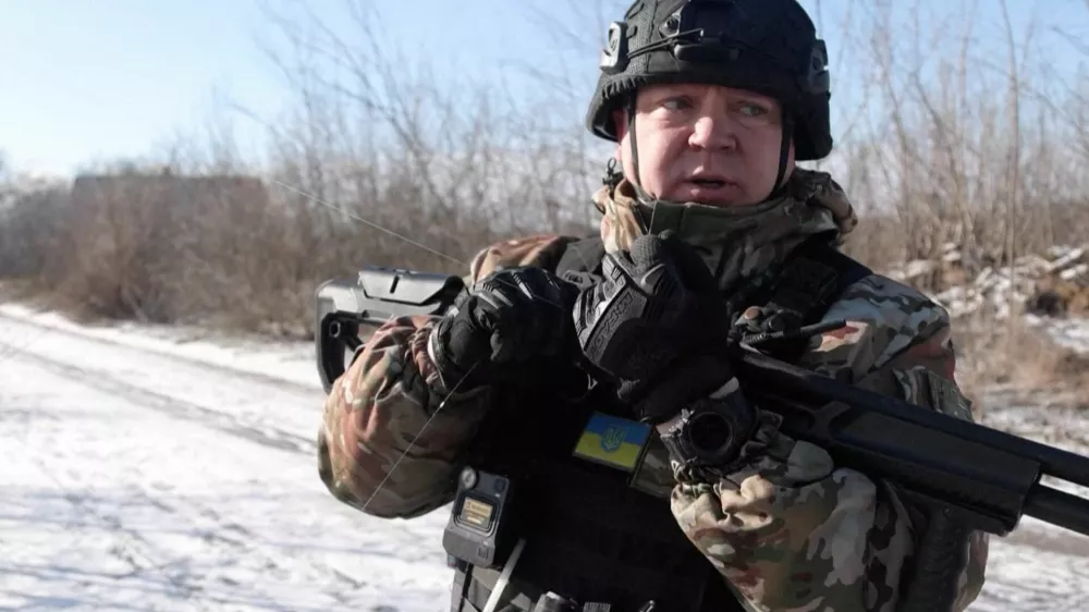 Ukrainian national police officer, holding a shotgun used as a counter-drone weapon, holds a drone fibre-optic cable, during an evacuation of residents from the Tavriiske and Yurkivka villages in Ukraine's Zaporizhzhia region, amid Russia's attack on Ukraine, in this screengrab from a video, February 3, 2026. Reuters TV via REUTERS THIS IMAGE HAS BEEN SUPPLIED BY A THIRD PARTY