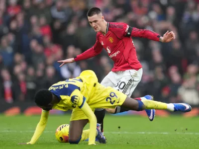 Tottenham's Pape Matar Sarr, left, and Manchester United's Benjamin Sesko fight for the ball during the English Premier League soccer match between Manchester United and Tottenham in Manchester, England, Saturday, Feb. 7, 2026. (AP Photo/Jon Super)