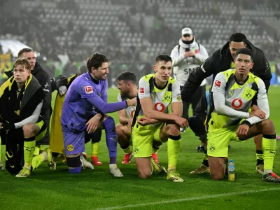 Soccer Football - Bundesliga - VfL Wolfsburg v Borussia Dortmund - Volkswagen Arena, Wolfsburg, Germany - February 7, 2026 Borussia Dortmund's Nico Schlotterbeck celebrates after the match with Jobe Bellingham and Gregor Kobel REUTERS/Carmen Jaspersen DFL REGULATIONS PROHIBIT ANY USE OF PHOTOGRAPHS AS IMAGE SEQUENCES AND/OR QUASI-VIDEO.