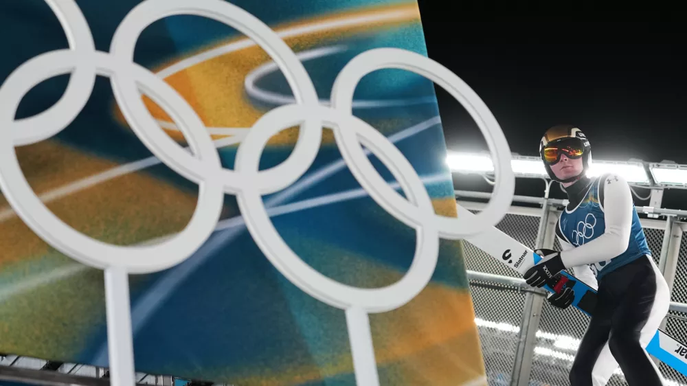 Domen Prevc, of Slovenia, carries his skis to the ramp for a jump during a ski jumping, men's normal hill, training session, at the 2026 Winter Olympics, in Predazzo, Italy, Sunday, Feb. 8, 2026. (AP Photo/Matthias Schrader)