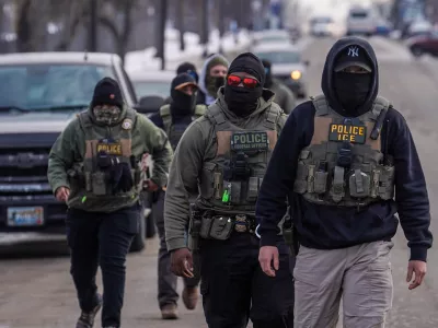 FILE - Federal agents walk down a street while conducting immigration enforcement operations, Thursday, Feb. 5, 2026, in Minneapolis. (AP Photo/Ryan Murphy, File)