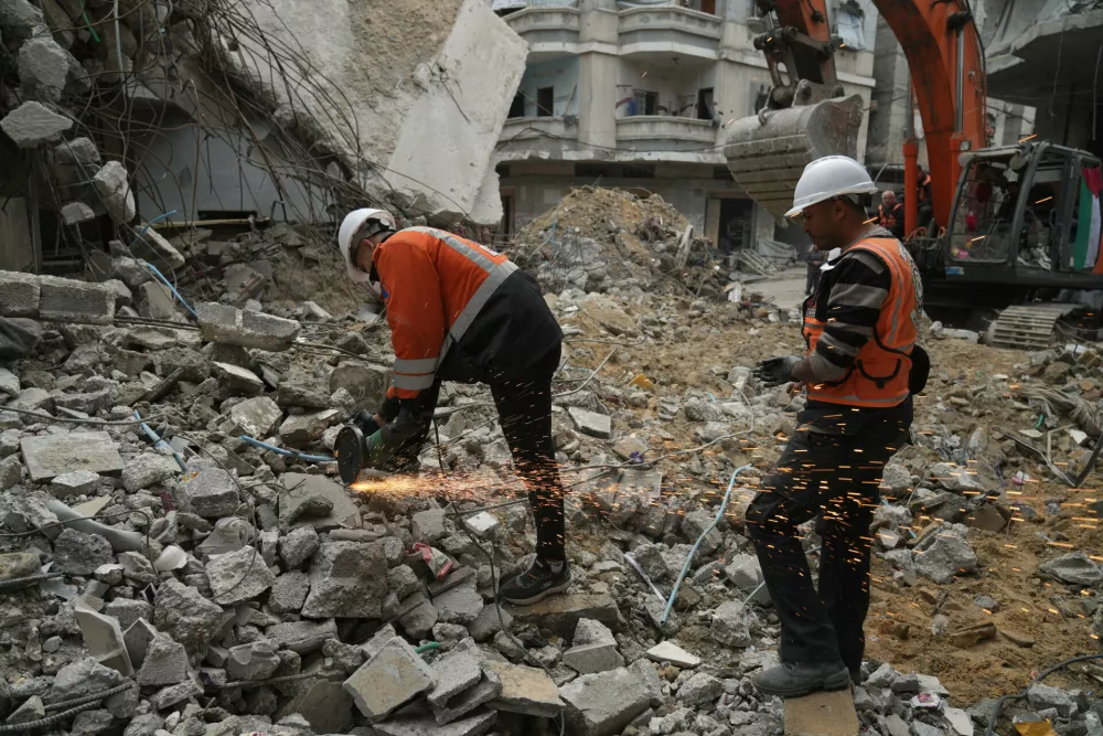Gaza's civil defense teams work to recover the remains of members of the Abu Nada family, who remain trapped beneath the rubble of their four-story house after it was destroyed by an Israeli airstrike in December 2023, in Gaza City, Monday, Feb. 9, 2026. (AP Photo/Jehad Alshrafi)
