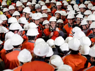 French President Emmanuel Macron, wearing a working helmet, gestures as he delivers a speech surrounded by employees as he visits the Mardyck Electryck site dedicated to the electric steel production at one of steelmaker ArcelorMittal's plants in Dunkirk, northern France, February 10, 2026. REUTERS/Benoit Tessier/Pool  TPX IMAGES OF THE DAY