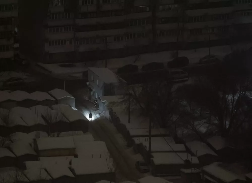 A resident uses flashlight as he walks during a power blackout after critical civil infrastructure was hit by Russian missile and drone attacks, amid Russia's attack on Ukraine, in Kyiv, Ukraine February 12, 2026. REUTERS/Gleb Garanich