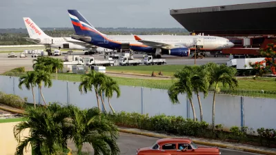 FILE PHOTO: The Aeroflot aircraft for the SU150 Moscow-Havana flight (R) is seen as a taxi drives out of a parking lot at Havana's Jose Marti International Airport June 24, 2013. REUTERS/Desmond Boylan/File Photo/File Photo