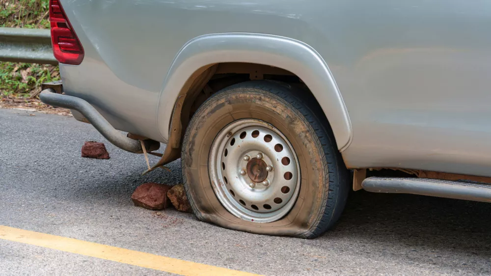 Pickup truck carrying overloaded produce suffered tire blowout while parked on rural highway during transportation of goods / Foto: Mumemories