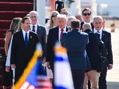 U.S. President Donald Trump walks with Israeli President Isaac Herzog, Israeli Prime Minister Benjamin Netanyahu and others at Ben Gurion International airport, on the day Israeli hostages are released by Hamas and Palestinian prisoners by Israel after a ceasefire went into effect under the first phase of a U.S.-brokered agreement, in Lod, Israel October 13, 2025. REUTERS/Yossi Zeliger  ISRAEL OUT. NO COMMERCIAL OR EDITORIAL SALES IN ISRAEL