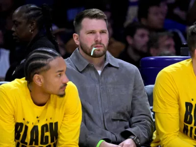 Feb 12, 2026; Los Angeles, California, USA; Los Angeles Lakers guard Luka Doncic (77) looks on from the bench as he chews on a dental flosser in the second half against the Dallas Mavericks at Crypto.com Arena. Mandatory Credit: Jayne Kamin-Oncea-Imagn Images
