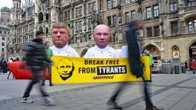 13 February 2026, Bayern, München: Greenpeace activists display giant sculptures of US President Donald Trump and Russian President Vladimir Putin standing on a 10-meter model gas tanker labeled "Fossil Gas" at Marienplatz in Munich. A banner reading "Break Free From Tyrants" accompanies the protest, marking the start of the Munich Security Conference. Photo: Malin Wunderlich/dpa